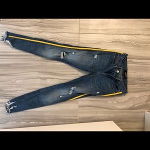 Ripper jeans with yellow stripe down the side.